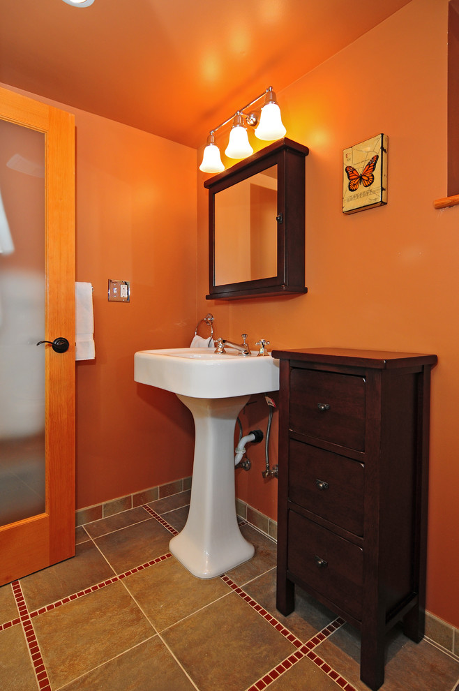 Inspiration for a classic shower room bathroom in Seattle with a pedestal sink, freestanding cabinets, dark wood cabinets, a two-piece toilet, multi-coloured tiles, ceramic tiles, orange walls and porcelain flooring.