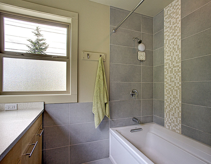 Inspiration för moderna badrum, med ett undermonterad handfat, släta luckor, skåp i ljust trä, bänkskiva i kvarts, ett badkar i en alkov, en dusch/badkar-kombination, en toalettstol med separat cisternkåpa, grå kakel, keramikplattor, gröna väggar och klinkergolv i keramik