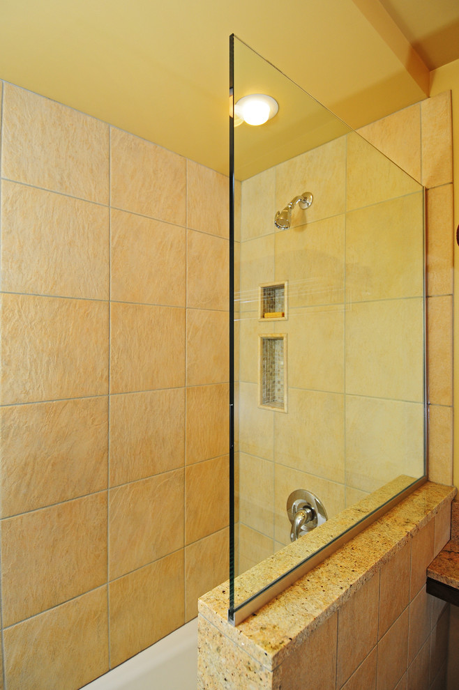 Idéer för ett modernt en-suite badrum, med ett undermonterad handfat, släta luckor, skåp i mellenmörkt trä, granitbänkskiva, ett badkar i en alkov, en dusch/badkar-kombination, en toalettstol med separat cisternkåpa, beige kakel, stenkakel, beige väggar och kalkstensgolv