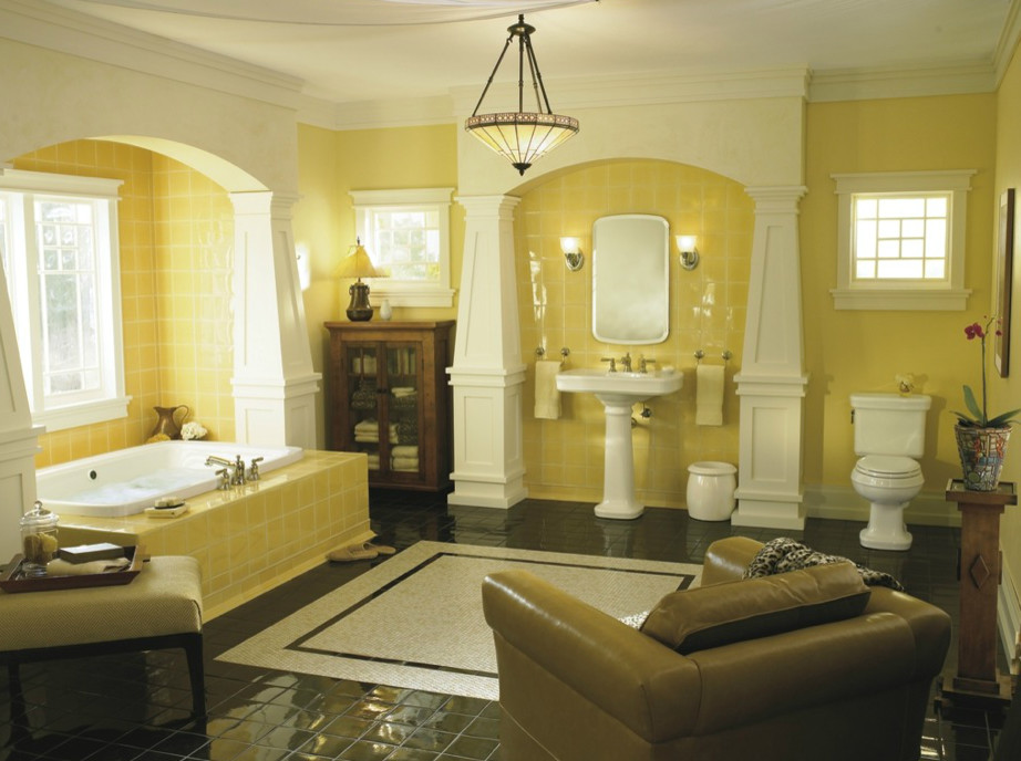 Стильный дизайн: большая главная ванная комната в классическом стиле с полновстраиваемой ванной, унитазом-моноблоком, желтой плиткой, керамической плиткой, желтыми стенами, полом из керамической плитки, раковиной с пьедесталом и коричневым полом - последний тренд