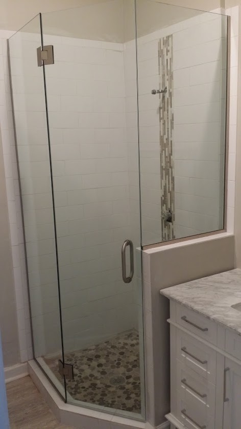 Ispirazione per una piccola stanza da bagno con doccia contemporanea con ante in stile shaker, ante bianche, doccia ad angolo, pareti beige, lavabo sottopiano, top in marmo, piastrelle multicolore e piastrelle di ciottoli