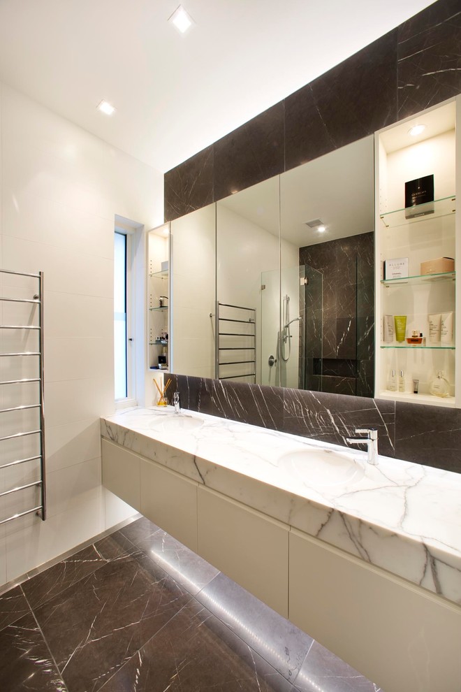 Пример оригинального дизайна: ванная комната в современном стиле с врезной раковиной, белыми фасадами и белой столешницей