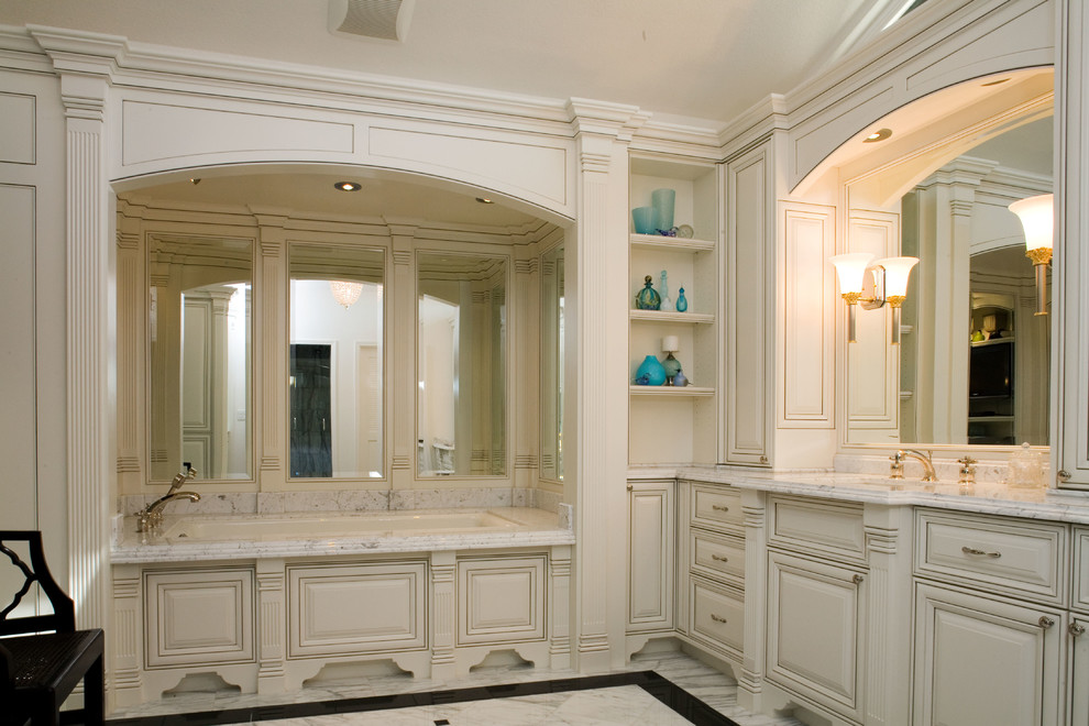 Inspiration pour une salle de bain principale traditionnelle de taille moyenne avec un lavabo encastré, un placard avec porte à panneau surélevé, des portes de placard blanches, un plan de toilette en marbre, une baignoire en alcôve, un carrelage blanc, un mur blanc et un sol en marbre.