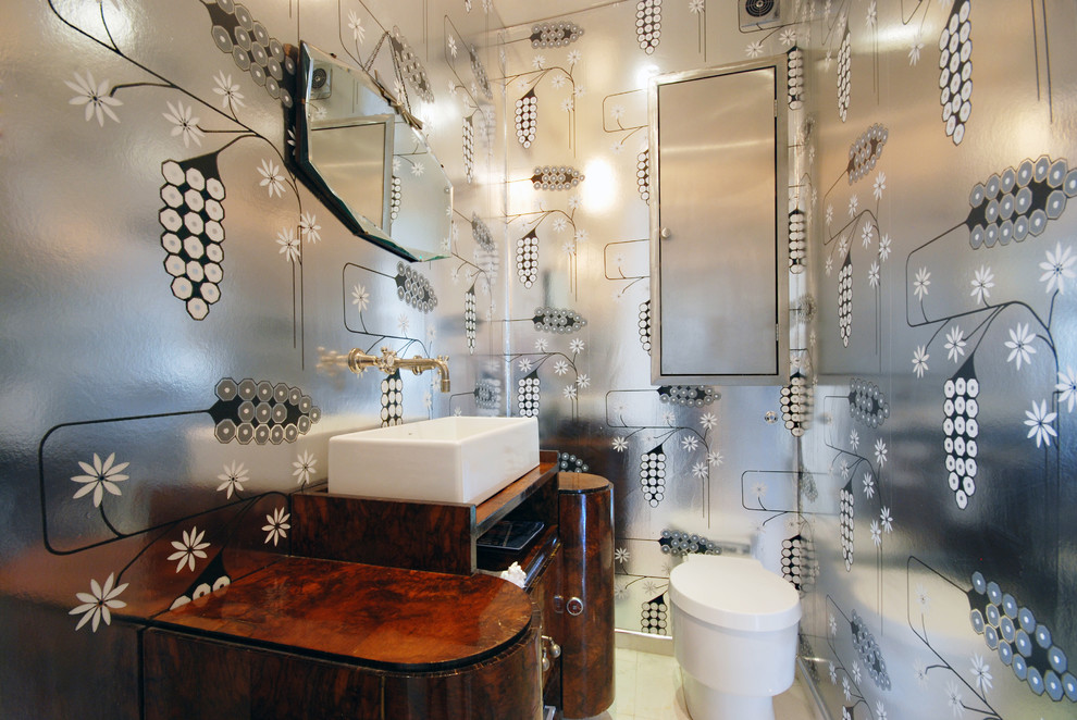 グロスタシャーにある高級な中くらいなコンテンポラリースタイルのおしゃれな浴室 (オーバーカウンターシンク、家具調キャビネット、濃色木目調キャビネット、木製洗面台、一体型トイレ	、グレーの壁、磁器タイルの床) の写真