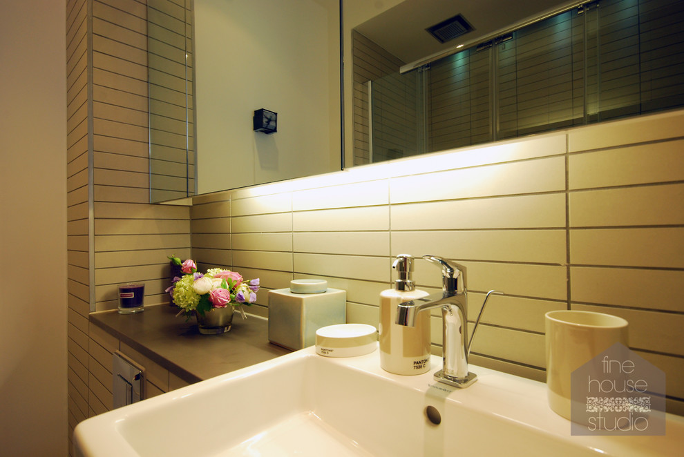 Inredning av ett modernt litet badrum med dusch, med ett väggmonterat handfat, släta luckor, bänkskiva i betong, en hörndusch, en toalettstol med hel cisternkåpa, beige kakel, keramikplattor och vita väggar
