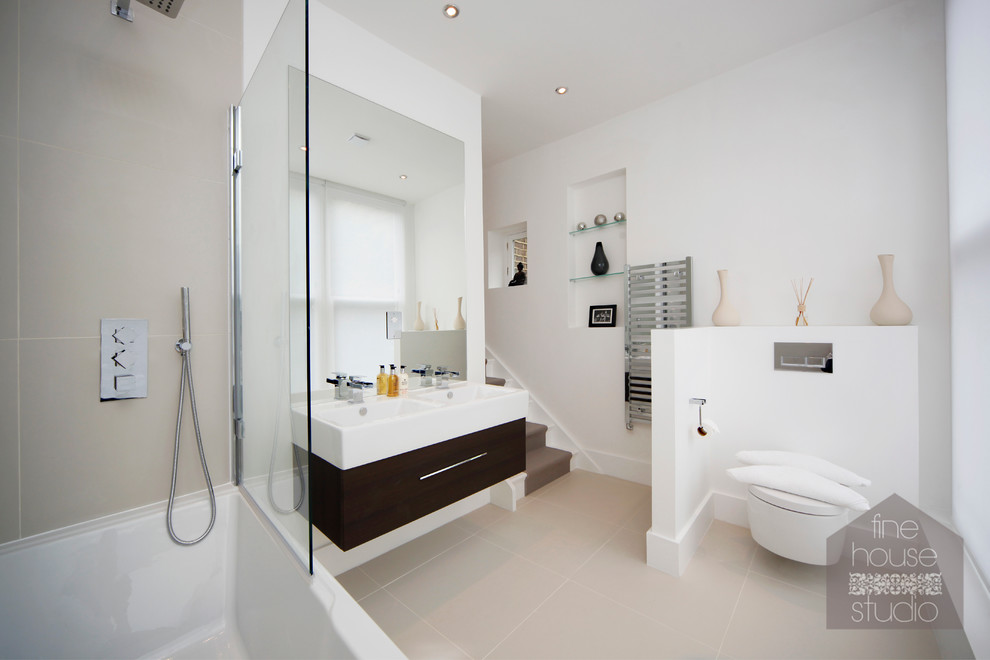 Photo of a medium sized modern ensuite bathroom in Gloucestershire with a wall-mounted sink, a wall mounted toilet, beige tiles, stone tiles, beige walls and porcelain flooring.