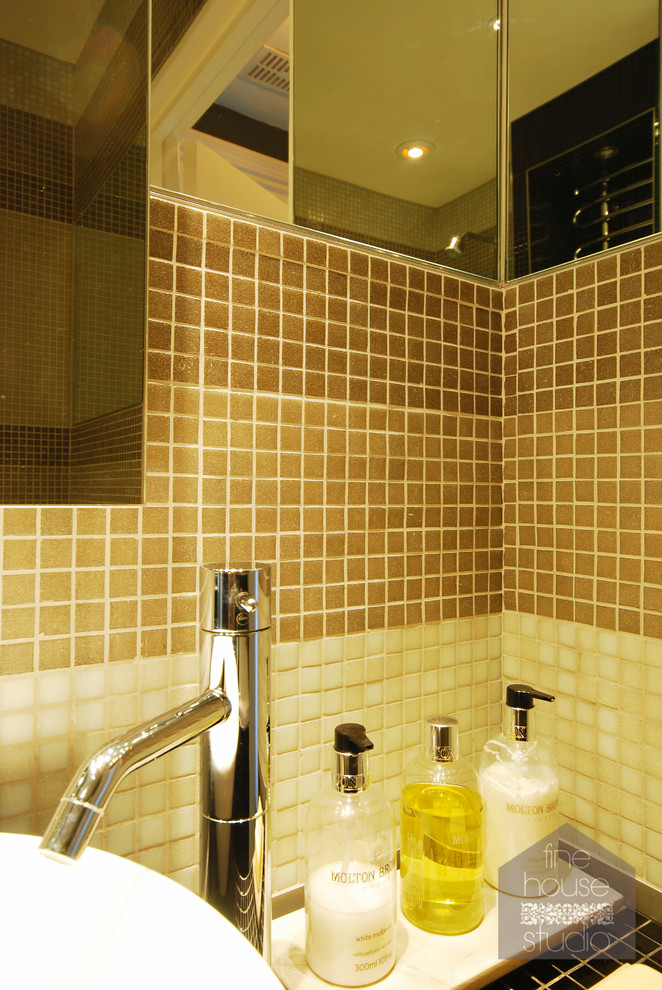 Foto på ett litet funkis badrum med dusch, med ett fristående handfat, kaklad bänkskiva, ett undermonterat badkar, en vägghängd toalettstol, svart kakel, mosaik, gula väggar och klinkergolv i keramik