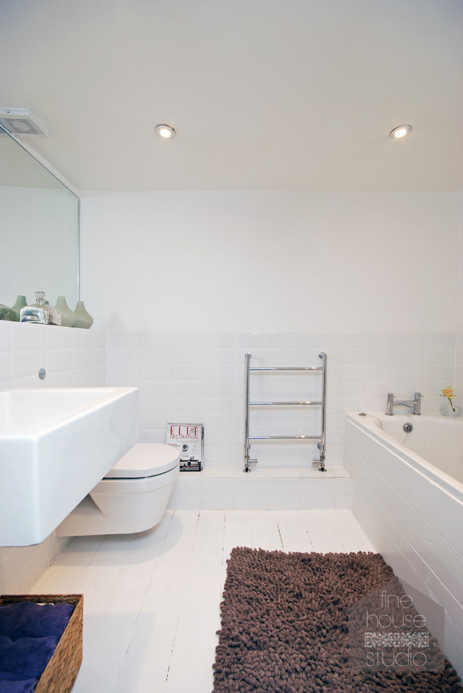 Foto på ett mellanstort maritimt en-suite badrum, med ett väggmonterat handfat, ett undermonterat badkar, en hörndusch, en vägghängd toalettstol, vit kakel, keramikplattor, vita väggar och ljust trägolv