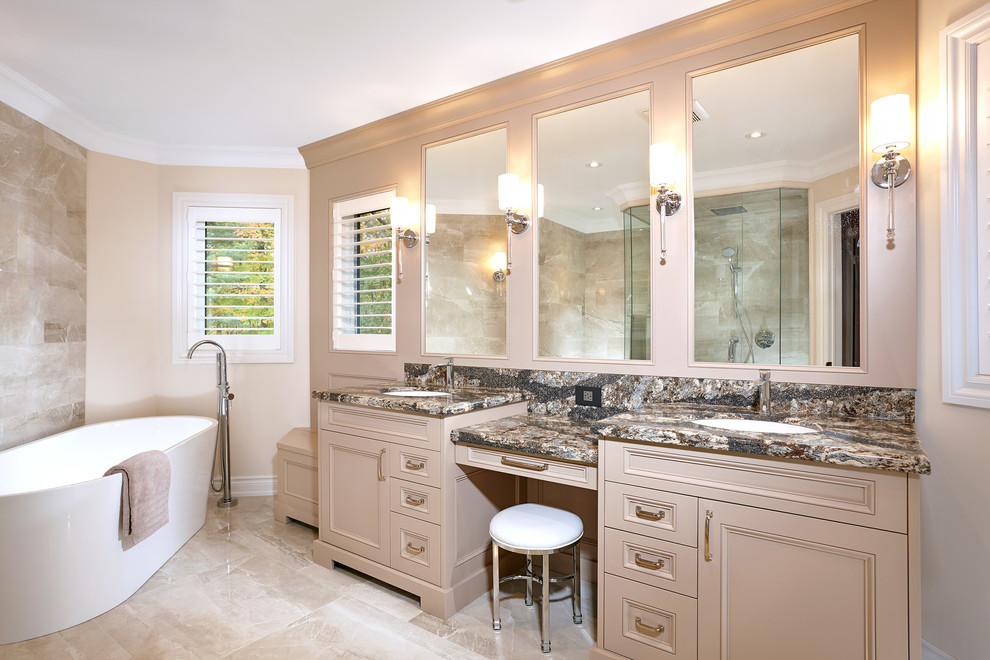 Photo of a medium sized classic ensuite bathroom in Toronto with recessed-panel cabinets, beige cabinets, a freestanding bath, a corner shower, beige tiles, marble tiles, beige walls, marble flooring, a submerged sink, quartz worktops, beige floors, a hinged door and multi-coloured worktops.