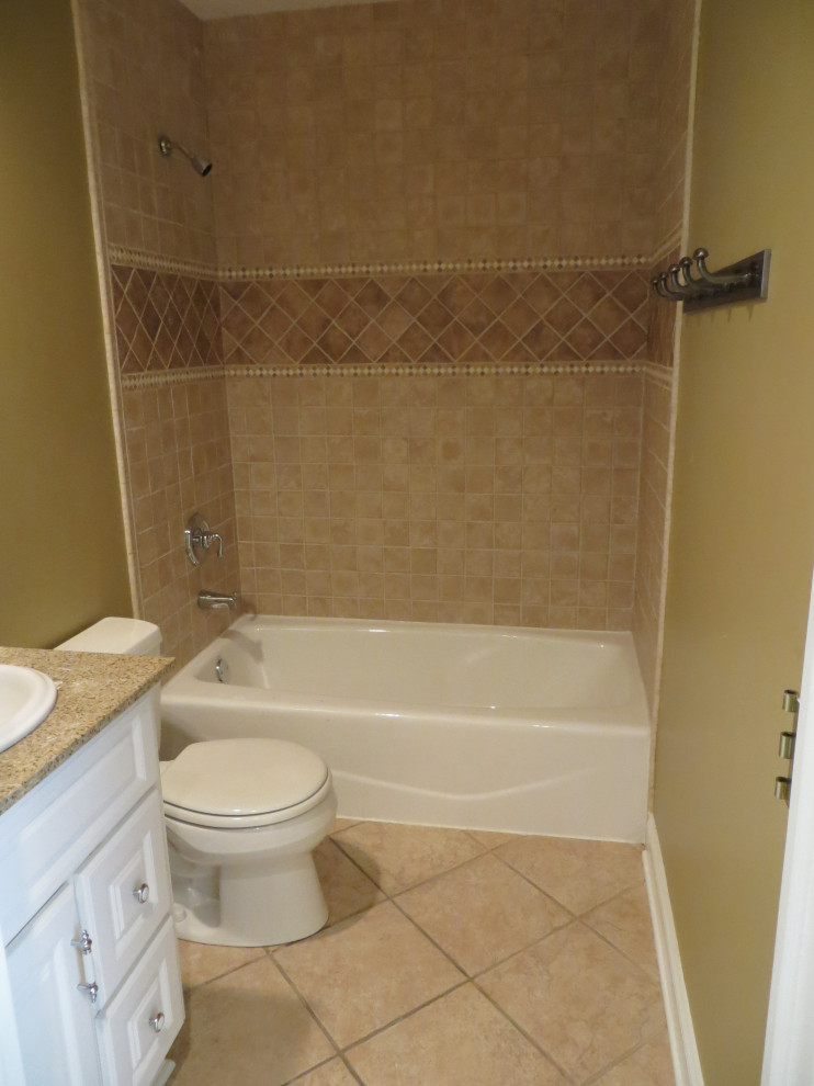 Bild på ett litet shabby chic-inspirerat beige beige badrum, med luckor med upphöjd panel, skåp i ljust trä, ett badkar i en alkov, en dusch i en alkov, en toalettstol med separat cisternkåpa, beige kakel, keramikplattor, gröna väggar, klinkergolv i keramik, ett nedsänkt handfat, granitbänkskiva, beiget golv och dusch med duschdraperi