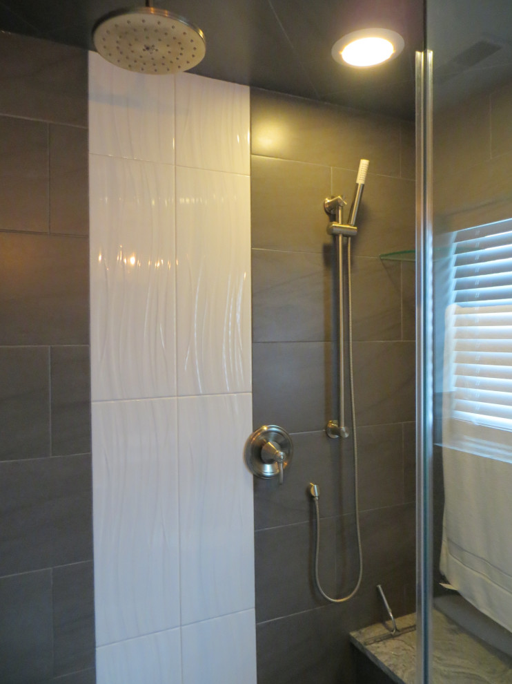 This is an example of a medium sized contemporary bathroom in Chicago with recessed-panel cabinets, dark wood cabinets, an alcove shower, grey tiles, ceramic tiles, a vessel sink, granite worktops, a hinged door and white worktops.