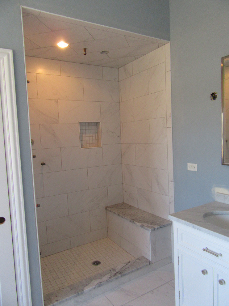 This is an example of a large modern ensuite bathroom in Chicago with raised-panel cabinets, white cabinets, a built-in bath, an alcove shower, a one-piece toilet, white tiles, ceramic tiles, blue walls, ceramic flooring, a submerged sink, granite worktops, white floors, an open shower and grey worktops.