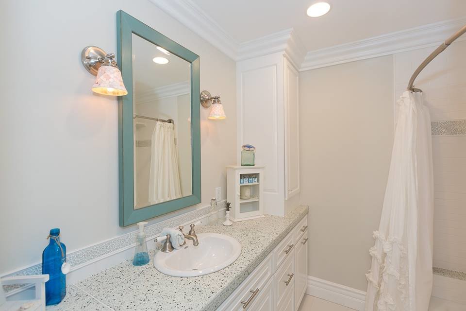 Diseño de cuarto de baño clásico renovado de tamaño medio con armarios con rebordes decorativos, puertas de armario blancas, ducha empotrada, paredes blancas, aseo y ducha, lavabo encastrado, encimera de terrazo, ducha con cortina y encimeras multicolor