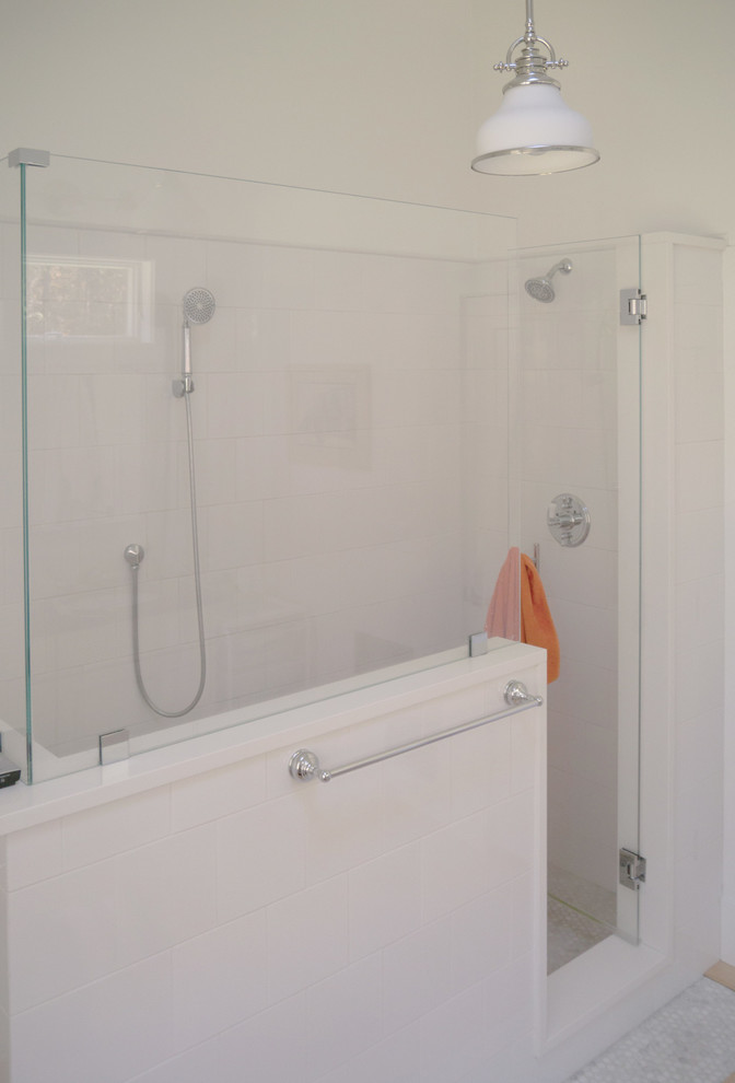 Foto på ett mellanstort funkis en-suite badrum, med luckor med infälld panel, vita skåp, träbänkskiva, en dusch i en alkov, vit kakel, tunnelbanekakel, vita väggar och ljust trägolv