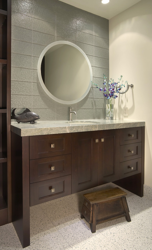 Immagine di una stanza da bagno design con lavabo sottopiano e ante in legno bruno