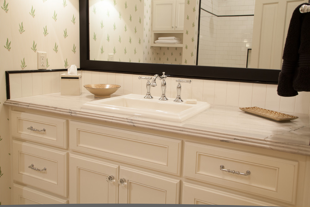 Foto di una piccola stanza da bagno con doccia classica con lavabo sottopiano, ante con riquadro incassato, ante bianche, top in marmo, piastrelle bianche, piastrelle in ceramica e pareti multicolore