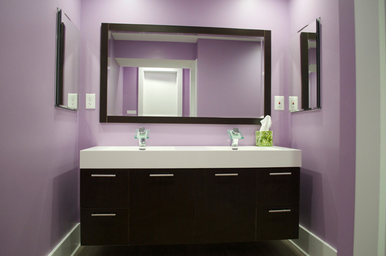 Réalisation d'une salle de bain principale en bois foncé avec un lavabo intégré et un mur violet.