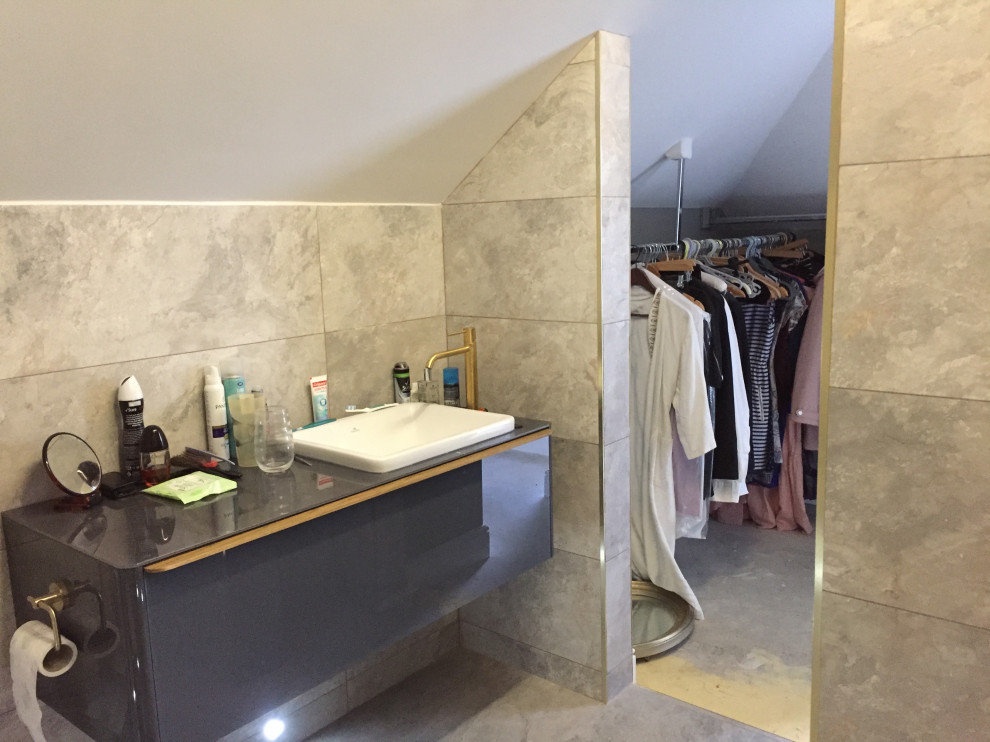 Small modern ensuite bathroom in Berkshire with open cabinets, grey cabinets, a built-in shower, a wall mounted toilet, grey tiles, ceramic tiles, grey walls, ceramic flooring, a wall-mounted sink, tiled worktops, grey floors, an open shower and white worktops.