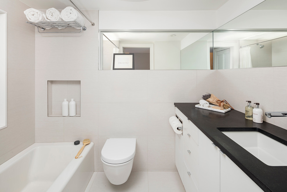 Bathroom - mid-sized contemporary white tile white floor bathroom idea in Boston with flat-panel cabinets, white cabinets, a wall-mount toilet and white walls