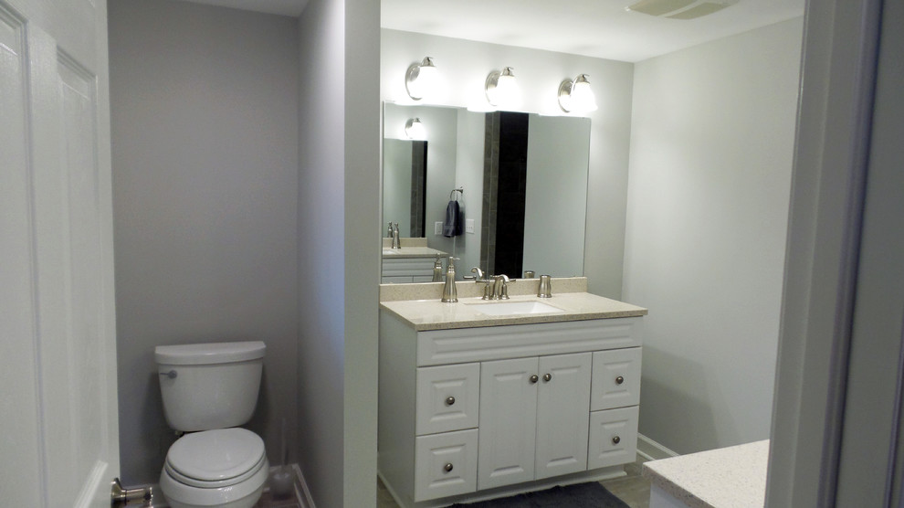Aménagement d'une salle de bain contemporaine de taille moyenne avec un placard avec porte à panneau surélevé, des portes de placard blanches, WC séparés, un mur gris, un lavabo encastré, un carrelage gris et des carreaux de porcelaine.