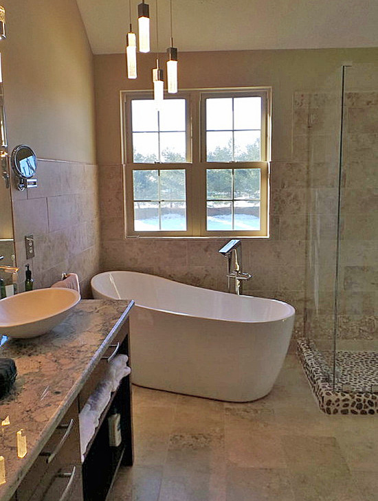 Cette photo montre une salle de bain principale tendance en bois brun de taille moyenne avec un placard sans porte, une baignoire indépendante, une douche d'angle, une plaque de galets, un mur beige, un sol en calcaire, une vasque et un plan de toilette en granite.