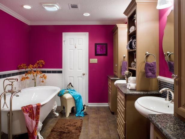 Идея дизайна: главная ванная комната среднего размера в классическом стиле с фасадами с выступающей филенкой, фасадами цвета дерева среднего тона, ванной на ножках, черной плиткой, стеклянной плиткой, розовыми стенами, столешницей из гранита и коричневым полом