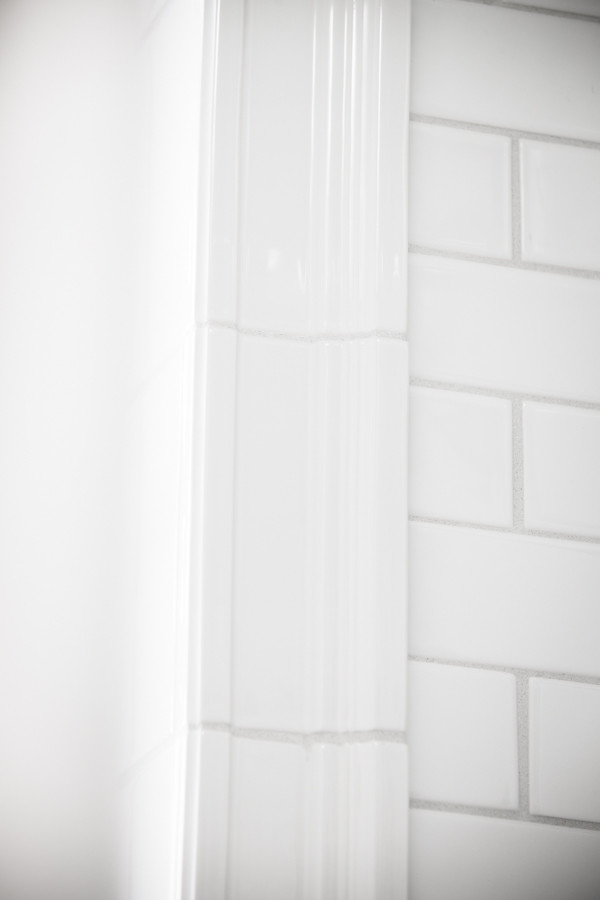 Kleines Retro Badezimmer mit Badewanne in Nische, Duschbadewanne, Wandtoilette mit Spülkasten, weißen Fliesen, Keramikfliesen, grüner Wandfarbe, Mosaik-Bodenfliesen und Wandwaschbecken in Omaha