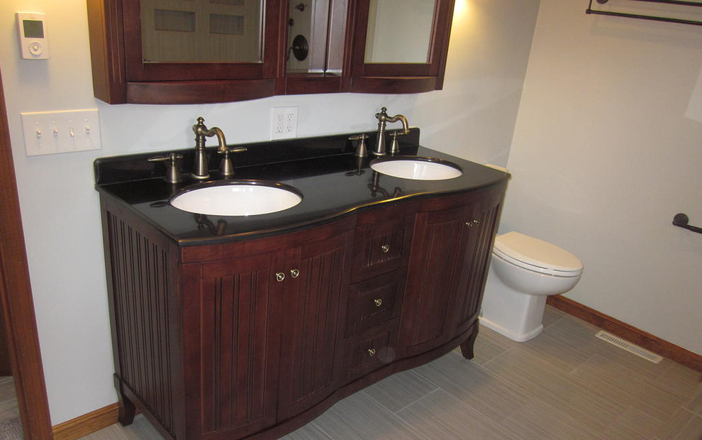 Mittelgroßes Badezimmer En Suite mit Unterbauwaschbecken, dunklen Holzschränken, Onyx-Waschbecken/Waschtisch, Toilette mit Aufsatzspülkasten, beigen Fliesen, weißer Wandfarbe und Keramikboden in Cincinnati