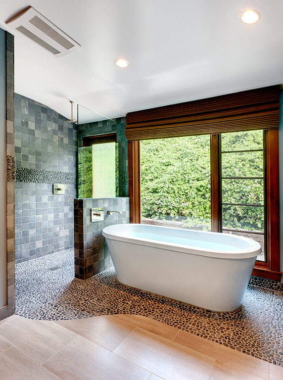 На фото: большая главная ванная комната в современном стиле с фасадами с выступающей филенкой, темными деревянными фасадами, отдельно стоящей ванной, открытым душем, серой плиткой, каменной плиткой, синими стенами, полом из галечной плитки, врезной раковиной, бежевым полом и открытым душем