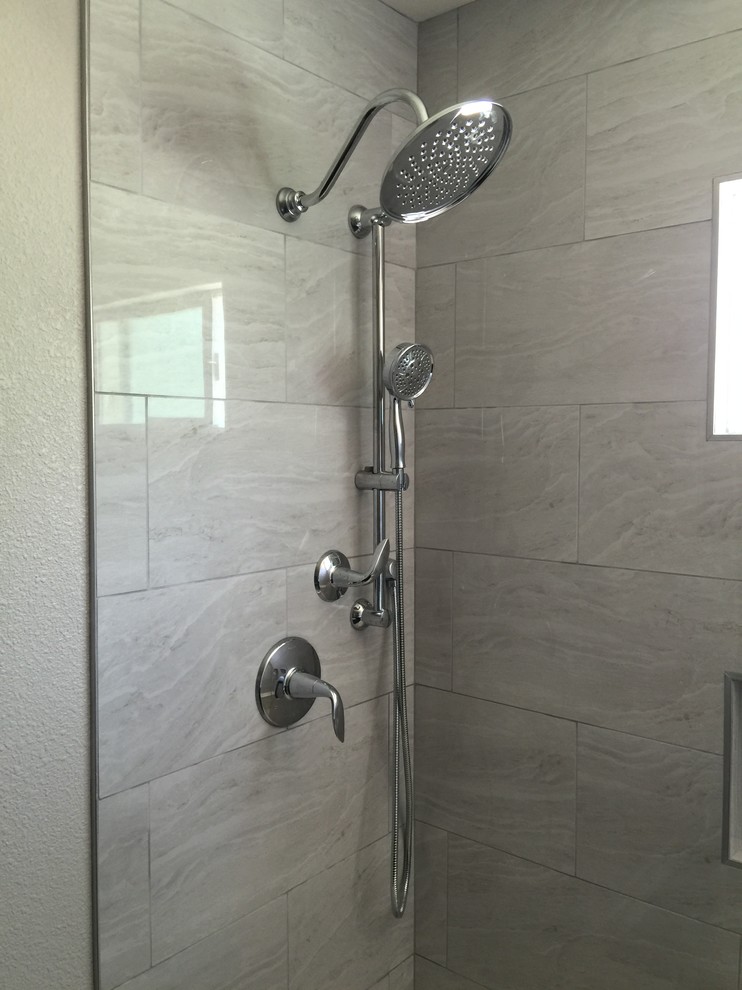 Large elegant gray tile and porcelain tile dark wood floor bathroom photo in Las Vegas with raised-panel cabinets, dark wood cabinets, an integrated sink and solid surface countertops