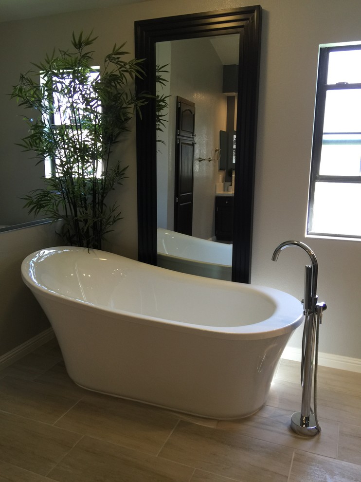 This is an example of a medium sized traditional bathroom in Las Vegas with a freestanding bath, grey walls and porcelain flooring.