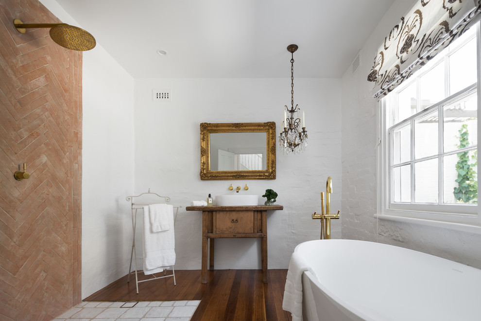Пример оригинального дизайна: ванная комната в средиземноморском стиле с синими фасадами, отдельно стоящей ванной, душем без бортиков, коричневой плиткой, белыми стенами, темным паркетным полом, настольной раковиной, коричневым полом и открытым душем