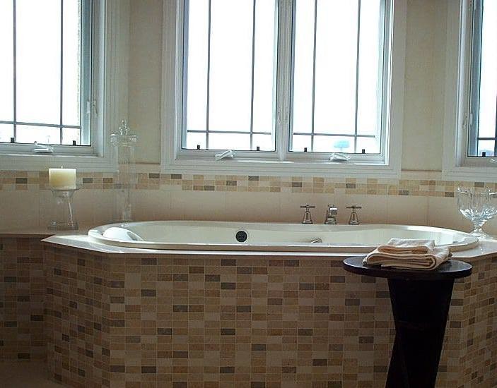 Exempel på ett badrum, med beige kakel, stenkakel, flerfärgade väggar, kalkstensgolv och ett platsbyggt badkar