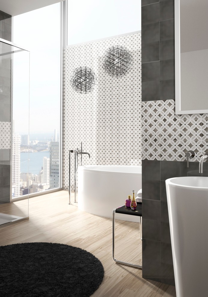 На фото: ванная комната в современном стиле с серой плиткой, керамической плиткой, серыми стенами, раковиной с пьедесталом, отдельно стоящей ванной и светлым паркетным полом