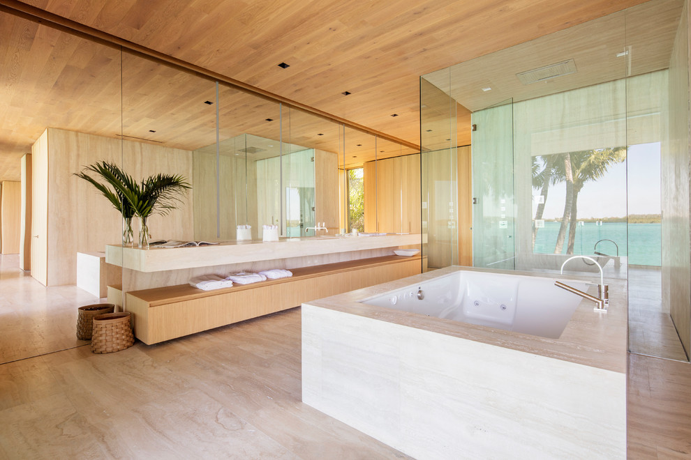 Inspiration for a contemporary ensuite bathroom in Miami with flat-panel cabinets, light wood cabinets, a submerged bath, a built-in shower, beige floors and a hinged door.