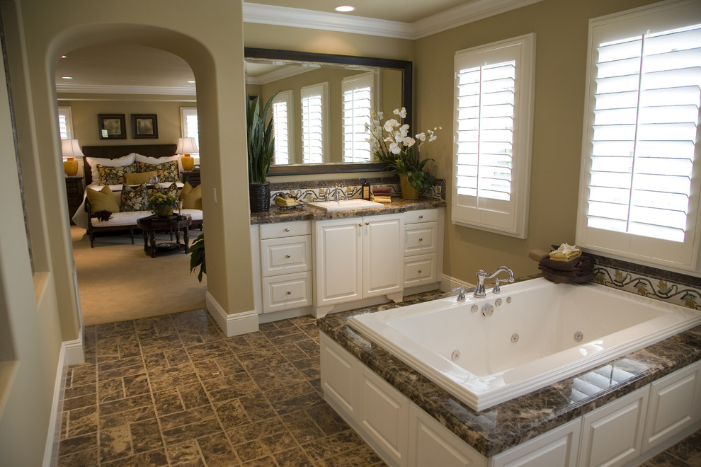 Idéer för att renovera ett stort vintage en-suite badrum, med luckor med upphöjd panel, vita skåp, ett platsbyggt badkar, beige väggar, klinkergolv i keramik, ett nedsänkt handfat och granitbänkskiva