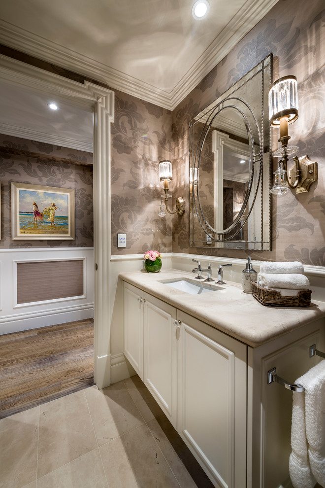 Cette photo montre une salle de bain chic avec un lavabo encastré, un placard avec porte à panneau encastré, des portes de placard blanches et un mur marron.