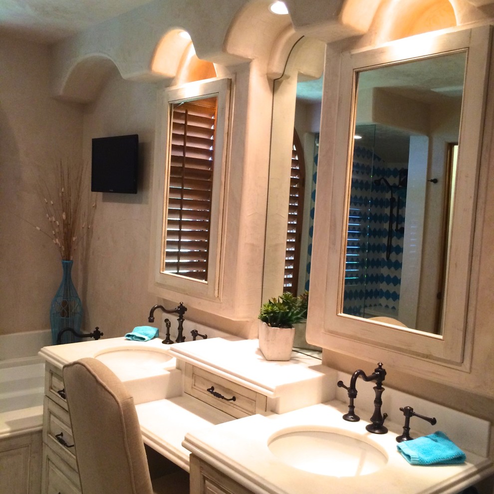 Klassisk inredning av ett mellanstort en-suite badrum, med blå kakel, luckor med upphöjd panel, skåp i slitet trä, ett undermonterat badkar, våtrum, porslinskakel, beige väggar, klinkergolv i keramik, ett undermonterad handfat, bänkskiva i akrylsten, blått golv och dusch med gångjärnsdörr