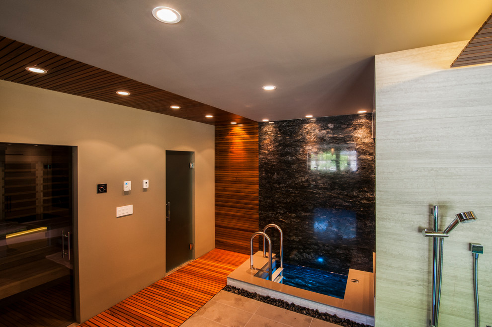 Réalisation d'un très grand sauna design en bois clair avec un placard à porte persienne, un bain japonais, un espace douche bain, WC à poser, un carrelage noir, des dalles de pierre, un sol en galet, un lavabo posé et un plan de toilette en quartz modifié.