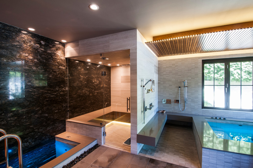 Cette image montre un très grand sauna design en bois clair avec un placard à porte persienne, un bain japonais, un espace douche bain, WC à poser, un carrelage noir, des dalles de pierre, un sol en galet, un lavabo posé et un plan de toilette en quartz modifié.