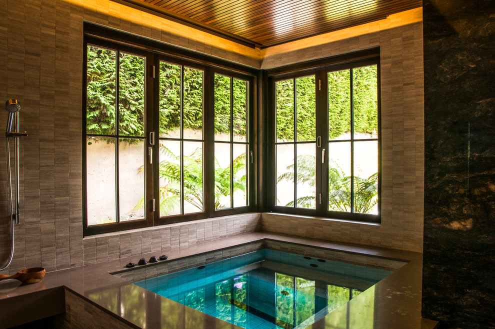 Exemple d'un très grand sauna tendance en bois clair avec un placard à porte persienne, un bain japonais, un espace douche bain, WC à poser, un carrelage noir, des dalles de pierre, un sol en galet, un lavabo posé et un plan de toilette en quartz modifié.