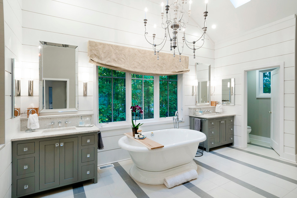 На фото: ванная комната в стиле кантри с фасадами в стиле шейкер, серыми фасадами, отдельно стоящей ванной, белыми стенами и врезной раковиной