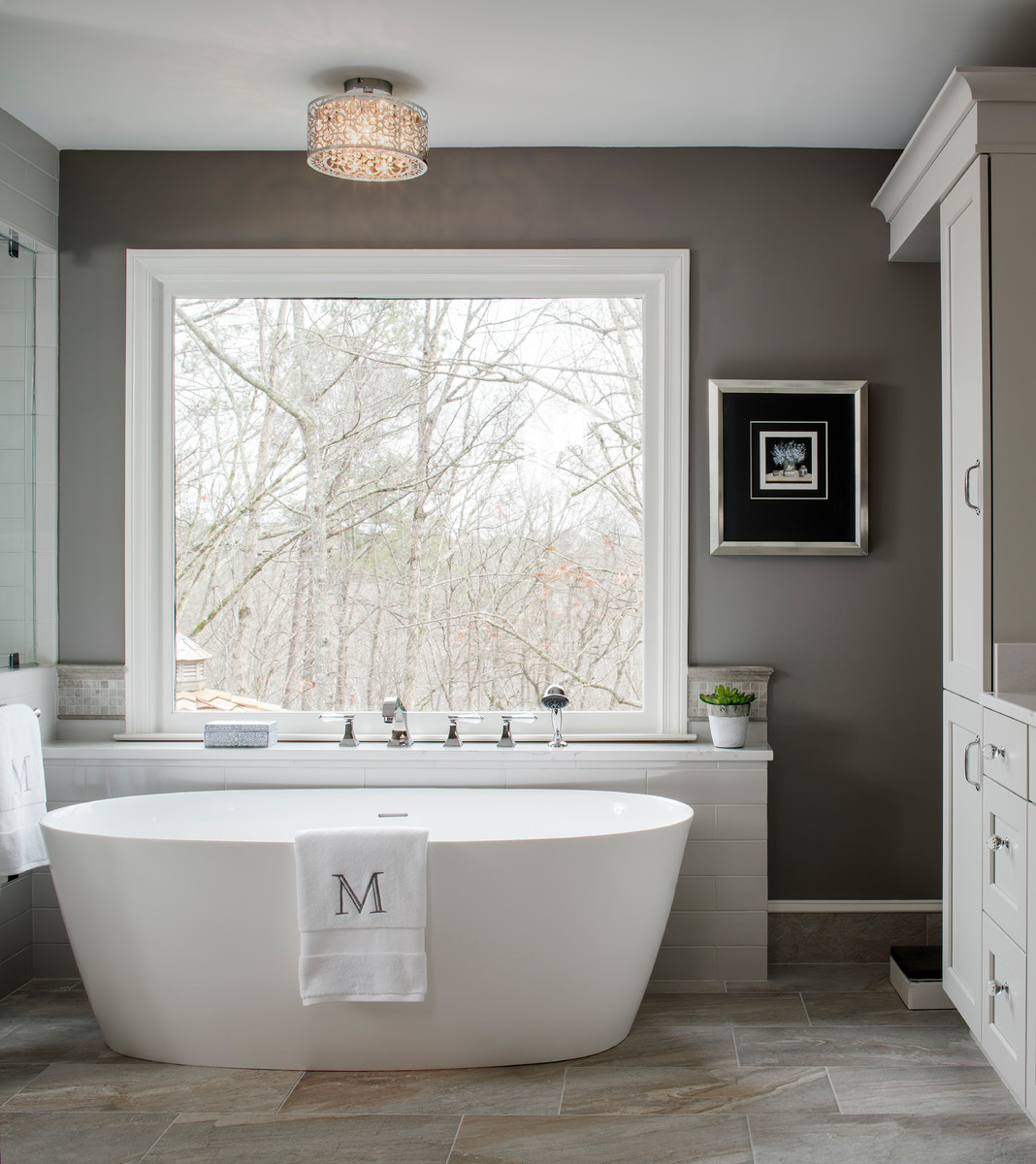 Photo of a large traditional ensuite bathroom in Atlanta with flat-panel cabinets, grey cabinets, a freestanding bath, a built-in shower, a two-piece toilet, grey tiles, ceramic tiles, grey walls, porcelain flooring, a submerged sink, engineered stone worktops, grey floors and a hinged door.