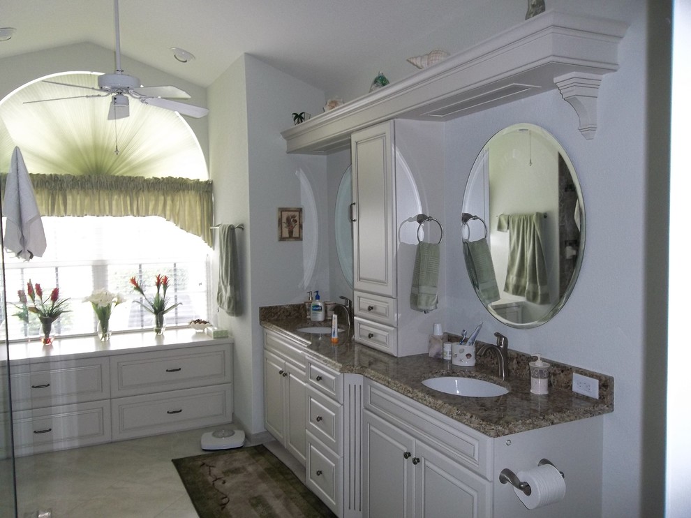 Idée de décoration pour une salle de bain principale tradition de taille moyenne avec un placard avec porte à panneau surélevé, des portes de placard blanches, un mur blanc, un sol en carrelage de céramique, un lavabo encastré et un plan de toilette en granite.