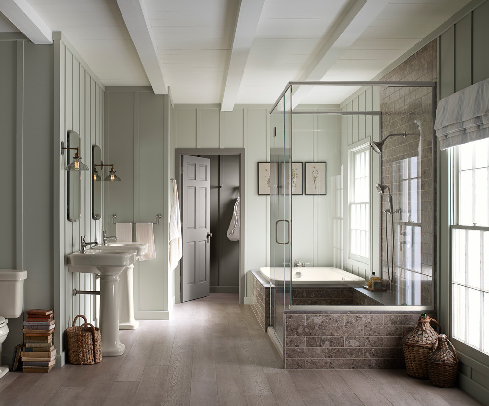 Foto di una grande stanza da bagno padronale country con lavabo a colonna, vasca da incasso, WC a due pezzi, pareti verdi e parquet chiaro
