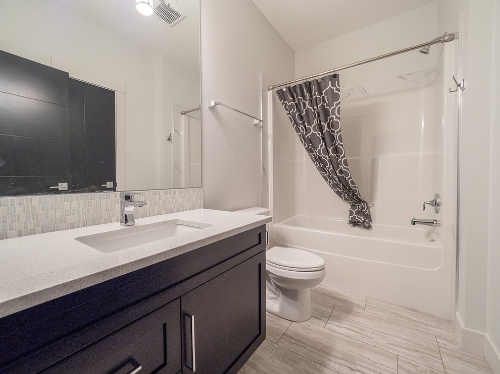 Свежая идея для дизайна: большая главная ванная комната в классическом стиле с фасадами с утопленной филенкой, черными фасадами, отдельно стоящей ванной, душевой комнатой, раздельным унитазом, белой плиткой, мраморной плиткой, белыми стенами, полом из винила, накладной раковиной, столешницей из кварцита, серым полом и душем с распашными дверями - отличное фото интерьера