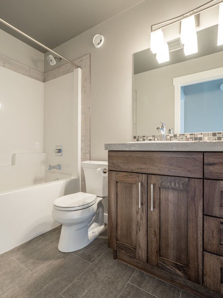 Inredning av ett modernt mellanstort en-suite badrum, med luckor med infälld panel, skåp i mellenmörkt trä, ett platsbyggt badkar, en dusch/badkar-kombination, en toalettstol med separat cisternkåpa, brun kakel, keramikplattor, grå väggar, vinylgolv, ett nedsänkt handfat, laminatbänkskiva, grått golv och dusch med duschdraperi
