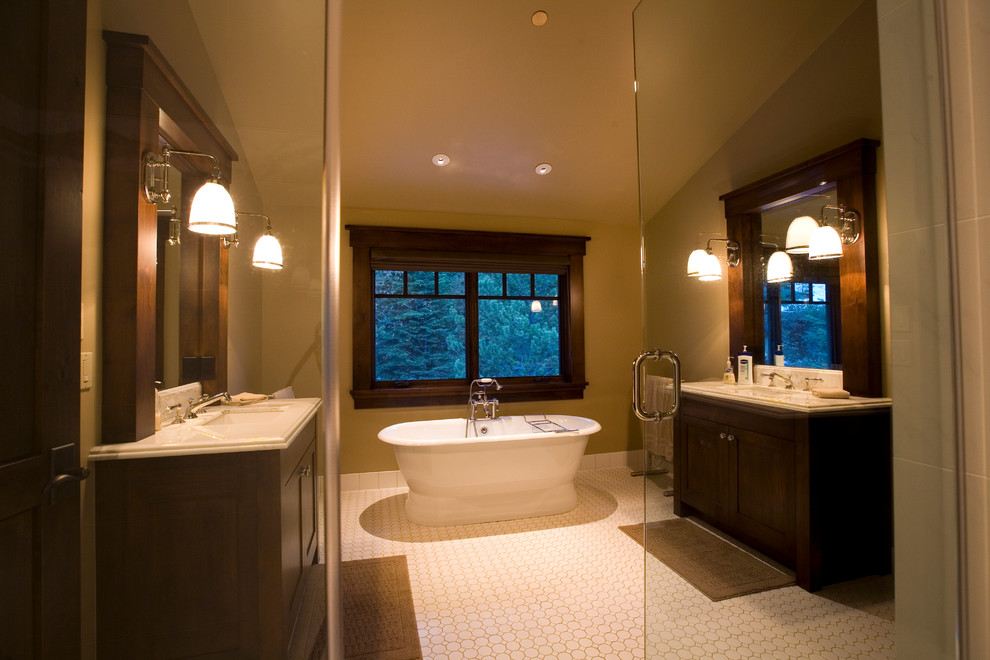 Exemple d'une salle de bain principale tendance en bois foncé avec une baignoire indépendante, un mur beige, un lavabo encastré, un sol blanc et une cabine de douche à porte battante.