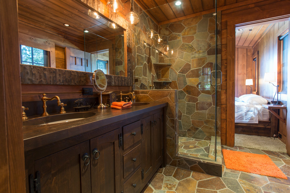 Immagine di una stanza da bagno rustica con ante in stile shaker, ante in legno bruno, doccia alcova, pavimento in ardesia, lavabo sottopiano e porta doccia a battente