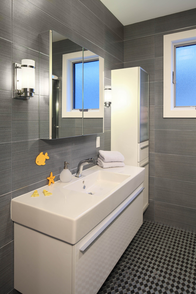 Esempio di una stanza da bagno contemporanea con lavabo integrato, ante lisce, ante bianche, piastrelle grigie e pavimento con piastrelle a mosaico